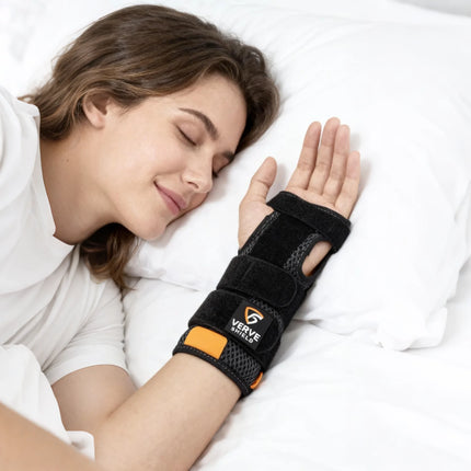 Person sleeping with a black wrist support brace on a white pillow