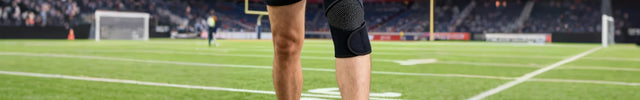 Person on a football field with VerveShield VK-03 knee brace and football